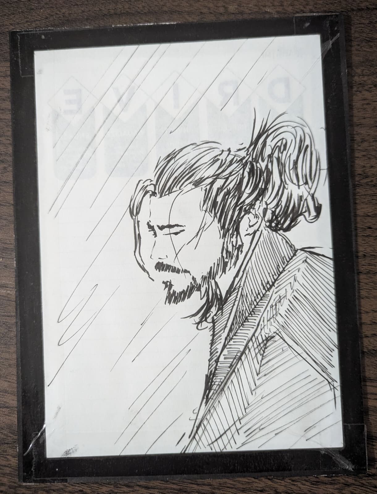Ink portrait of a man in rain, taped to a board